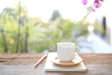 Coffee cup and notebook and pencil on wooden table