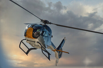 Fototapeta na wymiar helicopter flying in sky at sunrise