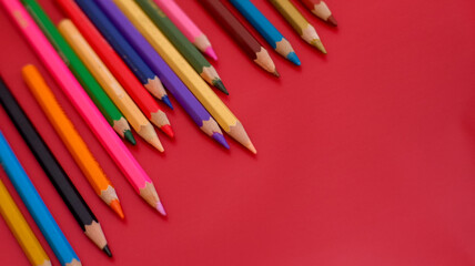 close up color pencil set, isolated on red background.