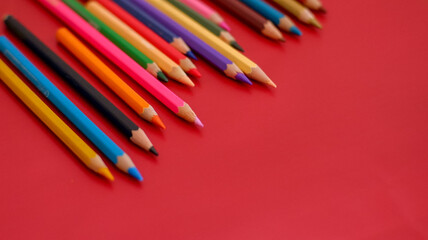 close up color pencil set, isolated on red background.