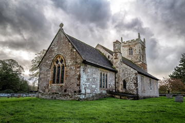 Fototapeta na wymiar Church of St Mary, in the village of Almer, Dorset, England. Dating from the 11th Century, this medieval church is in the Norman style