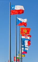 Flags of the world on flagpoles on the background of blue sky