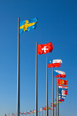 flags of the world on flagpoles on the background of blue sky