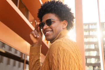Cool black man in trendy sweater and sunglasses