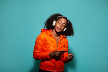 Black woman in outerwear listening to music