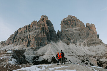 Zwei Personen in roten Jacken vor den drei Zinnen in den Dolomiten. Wandern Tre Cime. Letzte...