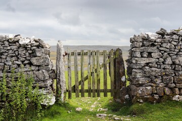 Closeup of a stone and wood gate in a field in the countryside of Yorkshire, England