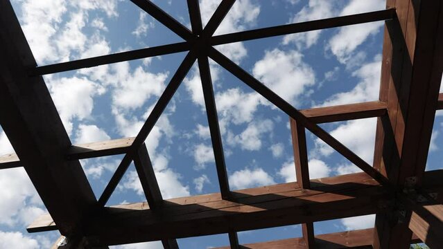 Wooden pergola in a city recreation park with a lake in the residential area