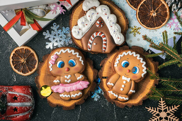 Christmas gingerbread house shaped cookie with white snow icing and gingerbread men on the winter festive background. Homemade traditional cookies. Gingerbread couple. Flat lay