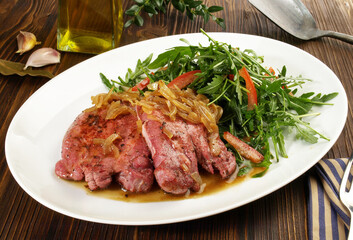 Fine Meat - Boiled Cured Veal Tongue Meat Slices with roasted Onions and Salad  on wooden Background