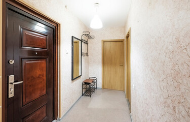 iron entrance door in spacious corridor, hallway of a bright apartment
