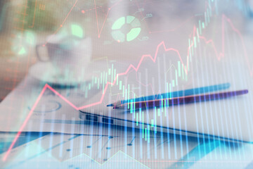 Forex graph hologram on table with computer background. Double exposure. Concept of financial...