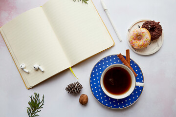Obraz na płótnie Canvas Mockup of empty notepad withwireless earphones, coffee cup with doughnuts. Online work, freelance, taking webinar, listen to music or audiobook, new normal. Cozy home.