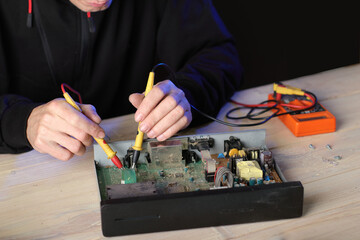 repair of an old satellite tuner by person on the table