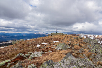 Fototapeta premium Scenic view from summit cross of mountain peak Gertrusk surrounded by alpine meadow, Saualpe, Lavanttal Alps, border Styria Carinthia, Austria, Europe. Hiking trail in Wolfsberg region on cloudy day