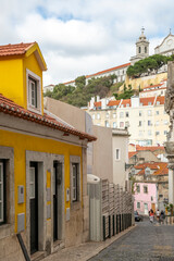 A street with vintage buildings on the slopes of a hill in the historic area of Lisbon in Portugal