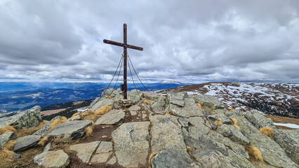 Scenic view from the summit cross of mountain peak Geierkogel, Saualpe, Lavanttal Alps, border Styria Carinthia, Austria, Europe. Hiking trail in Wolfsberg region on a cloudy day. Pilgrimage