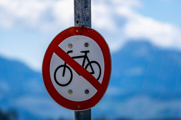 no cycling sign on a pale with blue mountain and sky background