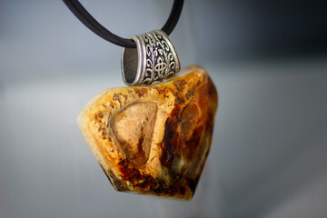 Amber necklace with silver ring on a blurry background