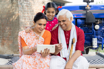 Indian rural daughter and grandfather using tablet at village