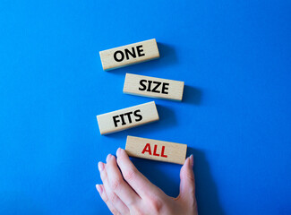 One size fits all symbol. Concept words One size fits all on wooden blocks. Beautiful blue background. Businessman hand. Business and One size fits all concept. Copy space.