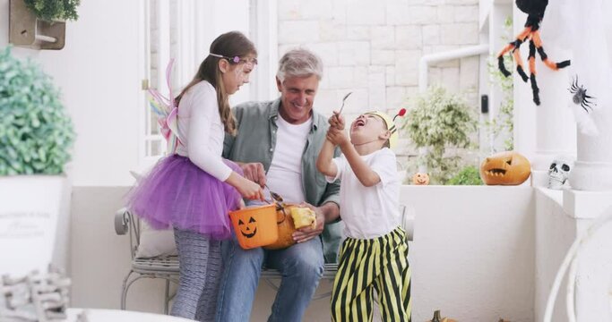 Children, halloween costume and candy for holiday celebration, senior man and children eating sweets. Celebrate, pumpkin lantern and kids having fun, party and comic happiness for spooky vacation