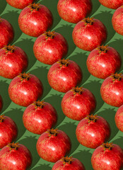 Pomegranate pattern. Red pomegranates on a green background. Fruit food concept.