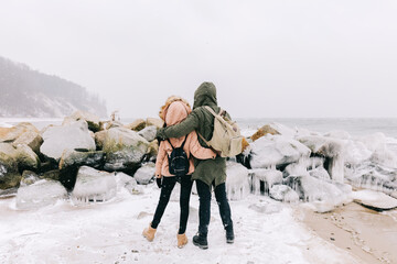 Couple trekking in winter by the sea.