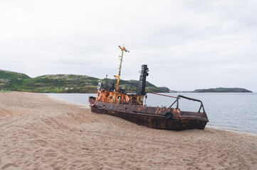 old abandoned painted ship on the seashore. a beached ship. Teriberka, Russia