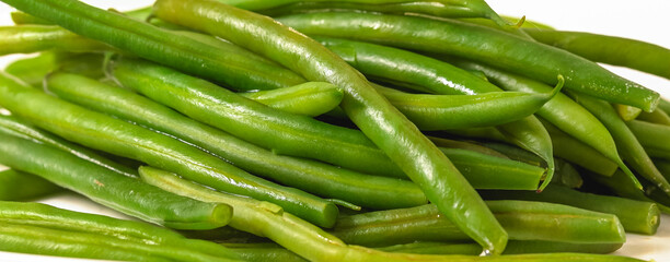 Boiled green beans close-up. French string beans, Haricots Verts, on white plate