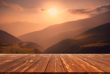 Fototapeta na wymiar Sunset over caucasus mountain range with empty wooden table. Natural template landscape