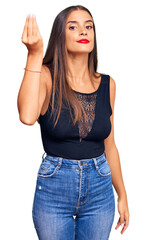 Young hispanic woman wearing casual clothes doing italian gesture with hand and fingers confident expression