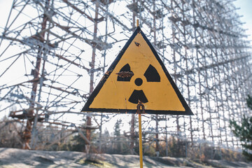 Yellow sign of radiation hazard against the background of the military building 