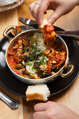 Shakshuka with bread in a pan. close up eating