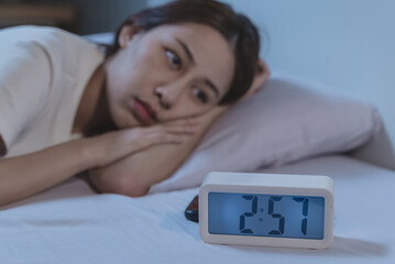 Close up on alarm clock in the night and woman have insomnia on the bed