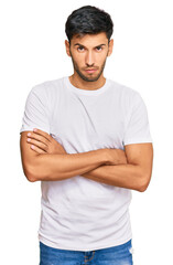Obraz premium Young handsome man wearing casual white tshirt skeptic and nervous, disapproving expression on face with crossed arms. negative person.