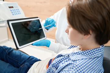 Dentist consulting a young patient in the dental office