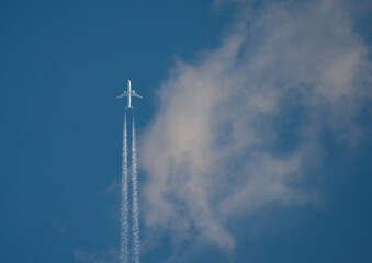 The airliner flies at high altitude, among the clouds. Vacations, trips - concept. - obrazy, fototapety, plakaty