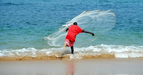 HOMBRE PESCANDO CON RED EN PLAYA DE DAKAR, SENEGAL