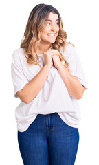 Young caucasian woman wearing casual clothes laughing nervous and excited with hands on chin looking to the side