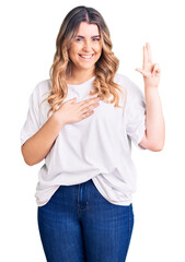 Young caucasian woman wearing casual clothes smiling swearing with hand on chest and fingers up, making a loyalty promise oath