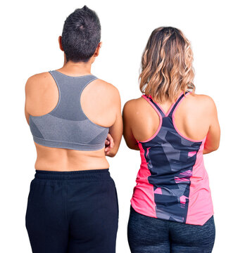 Couple of women wearing sportswear standing backwards looking away with crossed arms