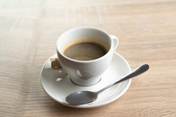 A cup of coffee on a saucer isolated on light background. Double Americano