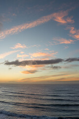Naklejka na ściany i meble Pink and golden clouds in blue sky, sunset over the sea. Bajamar, Tenerife, Canary Islands. 