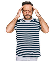 Fototapeta premium Middle age man wearing casual clothes and glasses with hand on head for pain in head because stress. suffering migraine.