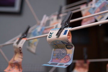 Euro banknotes on a drying line. Concept showing money laundering and illegal income.