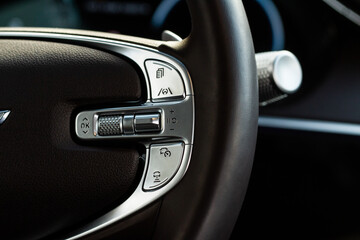 Cruise control switch closeup. Adaptive cruise control leaver. Cruise control on steering wheel.