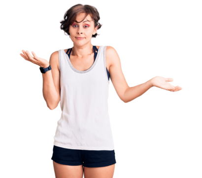 Beautiful young woman with short hair wearing casual sport clothes clueless and confused expression with arms and hands raised. doubt concept.