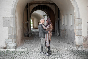 Obraz na płótnie Canvas love story of a loving couple.a couple - a girl and a guy walk and hug near the arch