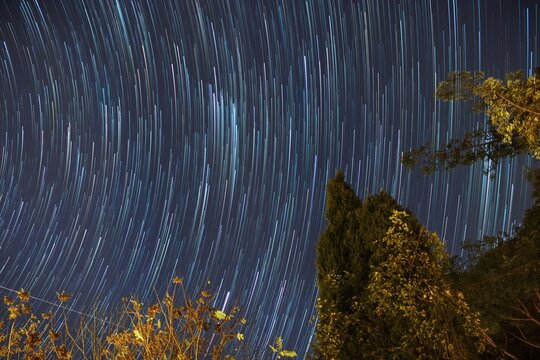 background with stars. Stars move around a polar star. Star trails in the night sky.
